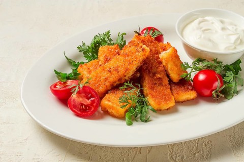 Fried fish nuggets, with white sauce, arugula and cherry, no people