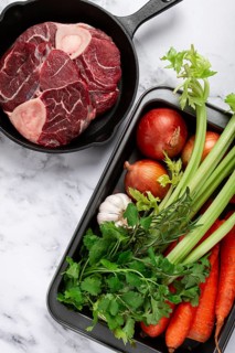 Sknuckle on the bone, raw meat for ossobuco, in a cast-iron pan, baking sheet with vegetables, top