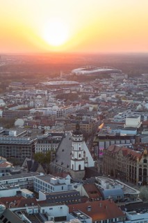 View of the city from the City Tower at sunset, St Thomas' Church, Red Bull Arena and Auwald