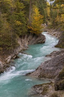 Rissbach creek flowing fast through the Riss valley. Autumn colors around