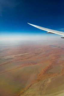 Landing approach over the desert to Abu Dhabi with the airline Etihad. View from the window of a