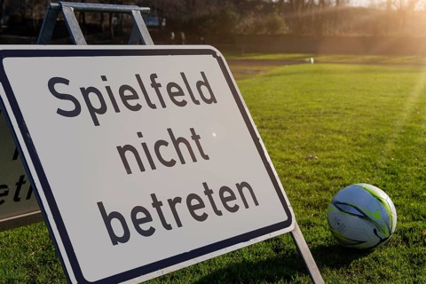 Symbolic image: Sign with the inscription Do not enter the pitch on a grass sports field