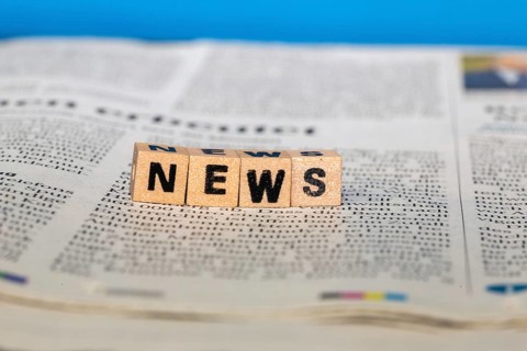 Symbolic image NEWS: Letter cube on a newspaper