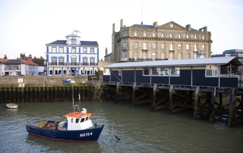 Fishing boat in harbour, Harwich, Essex, England, UK with Pier Hotel and Former Great Eastern Hotel
