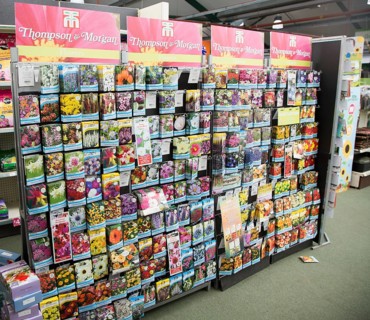 Thompson & Morgan packets of plant seeds on display inside a garden centre, Woodbridge, Suffolk,