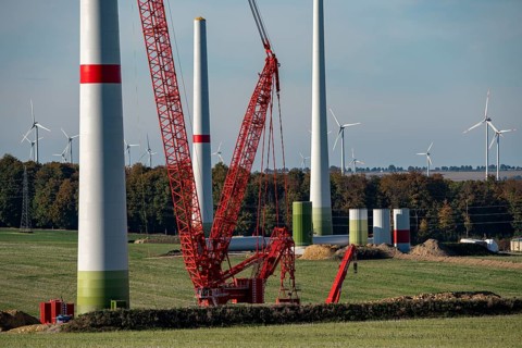 Assembly of a wind turbine, the last rotor blade is being mounted, mobile crane, wind turbine from