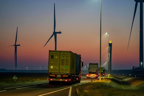 Lorry on the road from Euromax Terminal Rotterdam, ENECO wind farm on the dike around the port of
