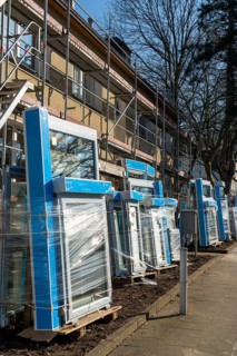 Energy-efficient refurbishment of residential buildings, older apartment block is scaffolded, gets