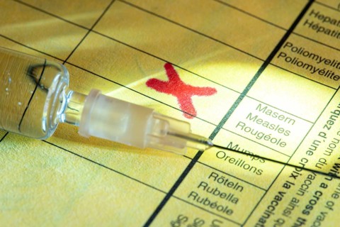Symbolic photo measles vaccination, vaccination certificate, syringe with measles vaccine