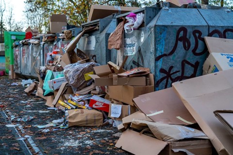 Overfilled waste paper containers, despite the overcrowding, people have put their waste paper next
