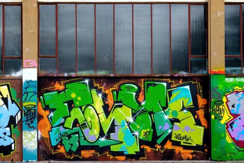 Colourful graffiti in shades of green and orange below windows, Landau, Rhineland-Palatinate,