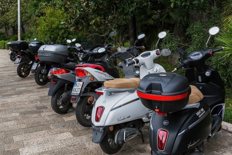 Black and white scooters including models Versilia 125 and Super B & W parked along the waterfront