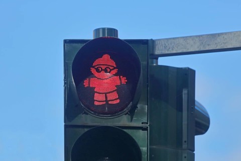 Red pedestrian traffic light with Mainzelmännchen as symbol for standing, waiting, stopping, halt,