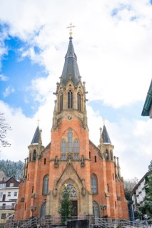 Gothic church with brick tower in front of a winter sky and surrounding buildings, St.Bonifatius,