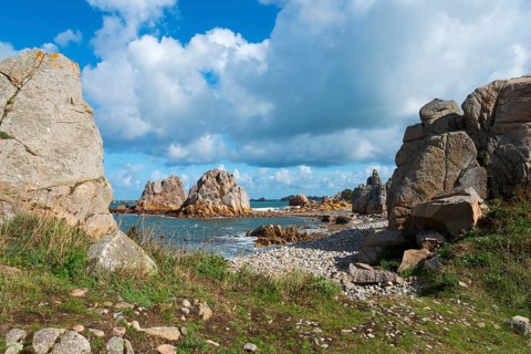 Coastal landscape with rocks, sea view and grassy paths under a cloudy sky, Plage de Pors Scaff,