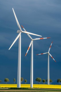 Wind turbines on a rape field, dark rain clouds, in the Rhenish lignite mining area, near