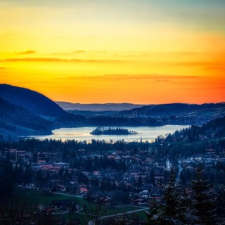 Idyllic landscape with lake and mountains at sunset, quiet village and bright sky, Schliersee
