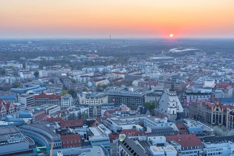 View of the city from the City Tower at sunset, St Thomas' Church, Red Bull Arena and Auwald