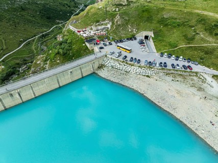 Dam of the Moiry lake, Lac de Moiry, turquoise glacial water, parking lot and restaurant at the