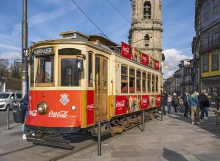 The iconic red tram number 18 pauses in front of the Clérigos Church Tower, Porto, Portugal, Europe