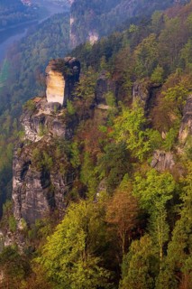The bright lit Wartturm above the Elbe river seen from the Bastei rocks near the village of Rathen