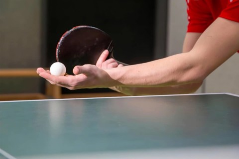 Table tennis symbol image: Close-up of a table tennis player serving