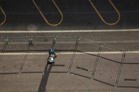 Top view of two middle aged women walking along a asphalt road surface in the port of La Spezia,