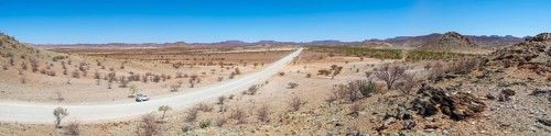 Panorama, gravel track leads through barren dry landscape with hills, Damaraland, Kunene, Namibia,