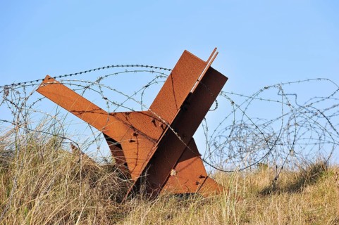 Barbed wire and Czech hedgehog static anti-tank defences from the Second World War on a beach in