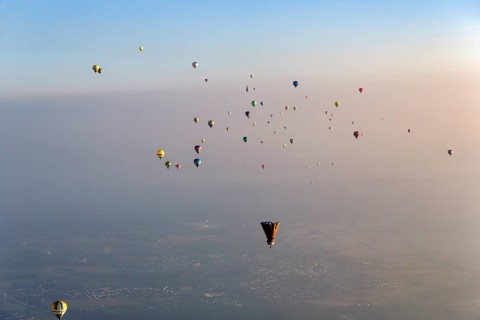 Many different hot air balloons on the way in the blue sky, distance, hot air balloon festival,