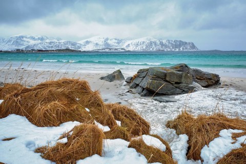 Waves of Norwegian sea on rocky beach of fjord. Ramberg beach, Lofoten islands, Norway, Europe