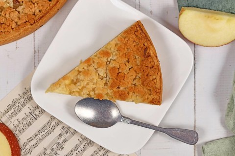 Slice of traditional European apple pie with topping crumbles called 'Streusel' on plate