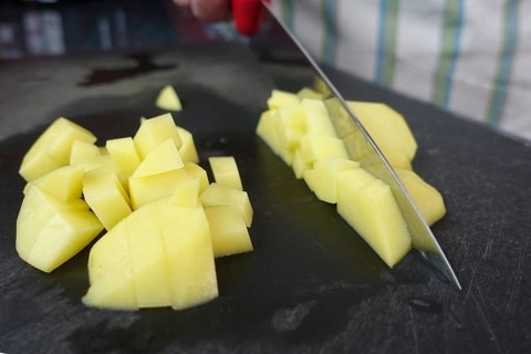 Preparation of a cress soup, cutting raw potatoes, cutting board, kitchen knife, chopping, Swabian