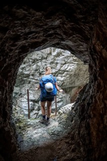 Hiker in a tunnel, Hammersbach flows through Höllentalklamm, near Garmisch-Partenkirchen,