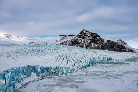 Snow-covered icebergs in the Fjallsarlon glacier lagoon, with the Öraefajökull glacier behind,
