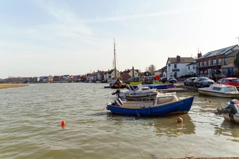 Boats and houses on waterside of River Colne, Rowhedge, Essex, England, UK