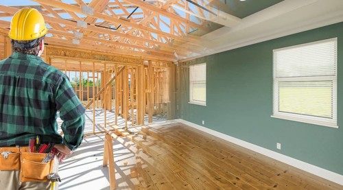 Contractor facing before and after interior of house wood construction framing and finished build