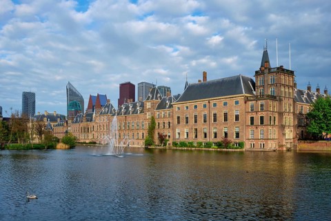 View of the Binnenhof House of Parliament and the Hofvijver lake with downtown skyscrapers in
