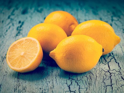 Vintage retro effect filtered hipster style image of five fresh ripe yellow lemons on blue wooden