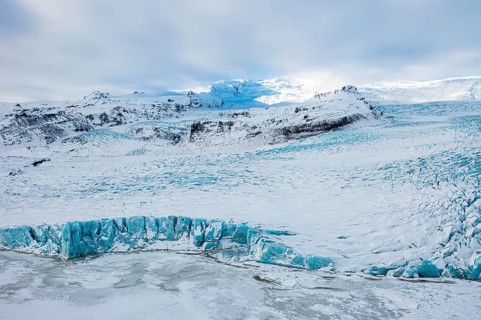 Snow-covered icebergs in the Fjallsarlon glacier lagoon, with the Öraefajökull glacier behind,