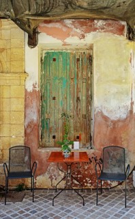 Table and chairs, seat in front of old door, Chania, Crete, Greece, Europe