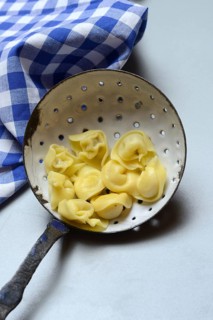 Cappelletti, cooked pasta in a sieve ladle, pasta