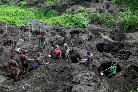 Egg collectors dig at the foot of the still active volcano Mount Tavurvur for eggs of Melanesian