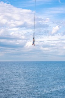 Bungy jumper on the rope over the sea, The Hague, Netherlands