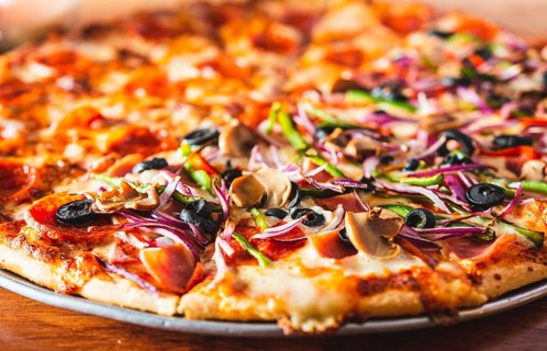 Close up of supreme pizza with olives on wooden table. Delicious Supreme Pizza and pepperoni on