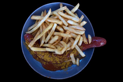 Currywurst with fries on a black background, Bavaria, Deutschalmd