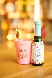 Team bride cup and a love champagne standing on a table