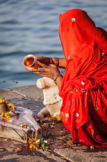 MAHESHWAR, INDIA, APRIL 26: Indian woman performs morning pooja on sacred river Narmada ghats on