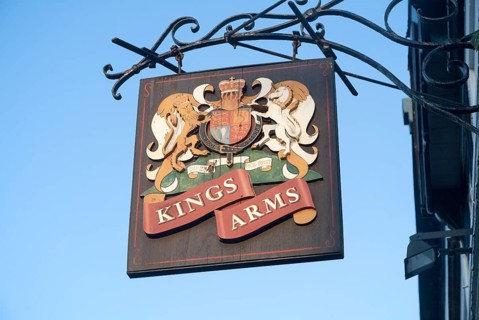 Close-up of pub sign for the Kings Arms against blue sky, Weymouth, Dorset, England, United
