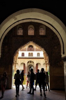 View through a gate, arabesque Moorish architecture, silhouette of tourists, Nasrid Palaces,
